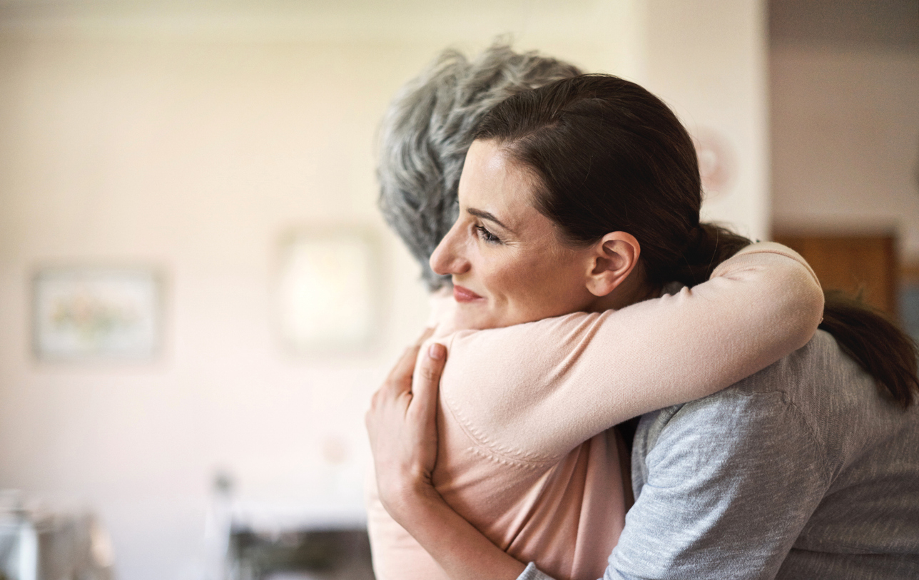 Shot of a young nurse hugging a senior woman in a retirement home